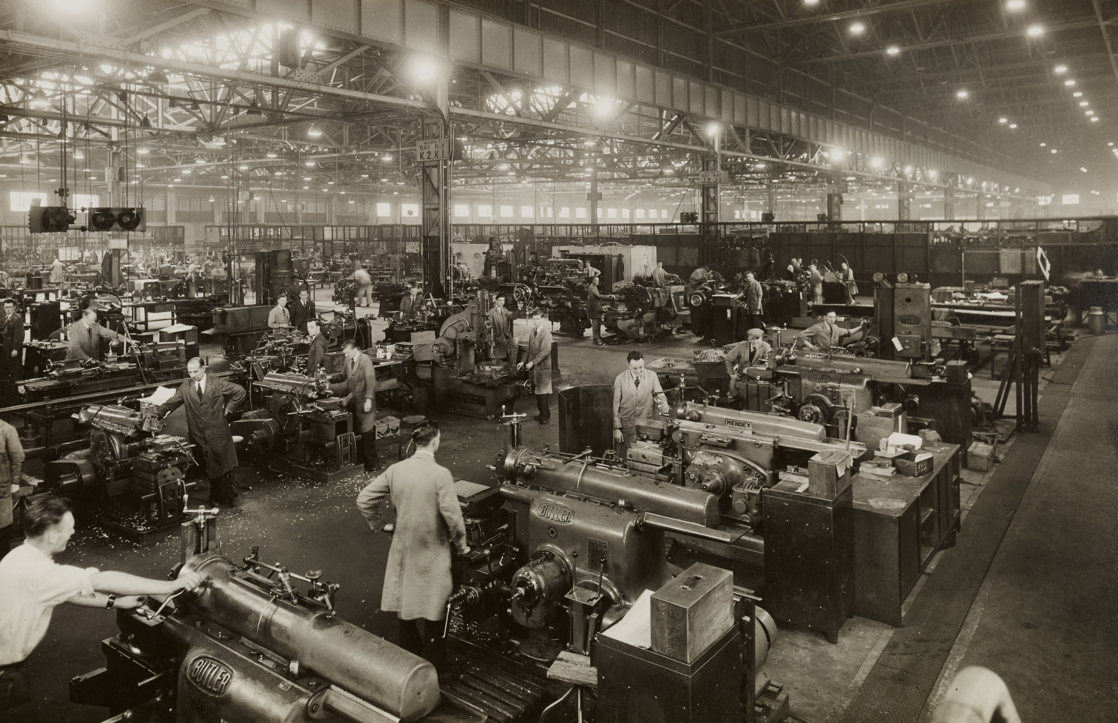 Black and white photo of people working in a large factory in Birmingham, England.